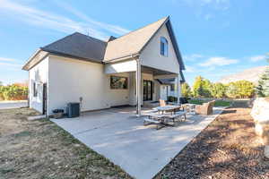 Back of property featuring roof with shingles, stucco siding, a patio, and a mountain view