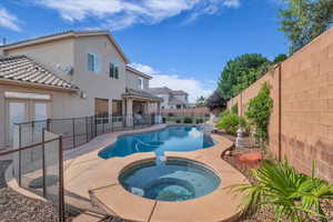 View of pool with a fenced backyard, a patio area, and a pool with connected hot tub