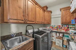 Washroom with washer and clothes dryer, cabinet space, and tile patterned flooring