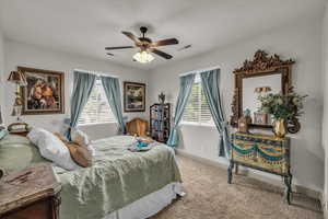 Carpeted bedroom with ceiling fan and baseboards