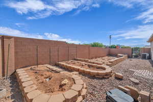 Fenced backyard with a gate and central air condition unit