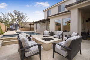 Fenced backyard featuring an outdoor fire pit, a patio area, and an in-ground hot tub
