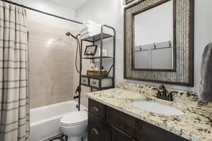 Full bathroom with shower / bath combo, vanity, and toilet