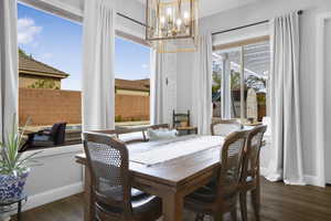 Dining area featuring a chandelier, wood finished floors, and baseboards