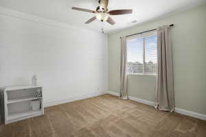Empty room with carpet, a ceiling fan, and baseboards