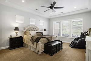 Bedroom featuring light carpet, baseboards, recessed lighting, a raised ceiling, and a ceiling fan