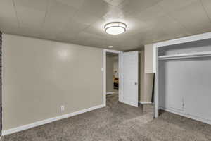 Unfurnished bedroom with carpet flooring, a closet, and baseboards