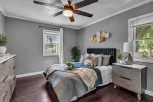 Bedroom with multiple windows, dark wood-style flooring, baseboards, crown molding, and a textured ceiling
