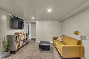 Living area featuring carpet floors, baseboards, and recessed lighting