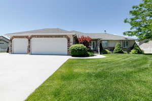 Ranch-style home featuring an attached garage, concrete driveway, stone siding, and stucco siding