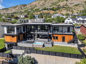 Rear view of property with stairs, a fenced backyard, a mountain view, a patio area, and a residential view