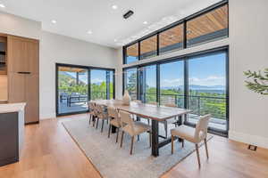 Dining space with baseboards, a mountain view, light wood-style flooring, and recessed lighting