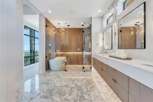 Full bath with a stall shower, a freestanding bath, vanity, recessed lighting, and marble tiled floors