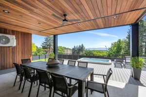View of patio / terrace with an outdoor hot tub, outdoor dining space, ac unit, a ceiling fan, and a deck with mountain view