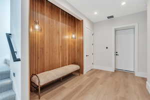 Entryway featuring light wood finished floors, baseboards, and recessed lighting