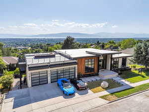 Contemporary home featuring a mountain view, a balcony, concrete driveway, and an attached garage
