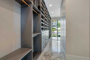 Walk in closet featuring light marble finish floors