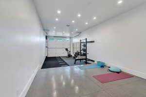 Workout room featuring a garage, recessed lighting, and baseboards
