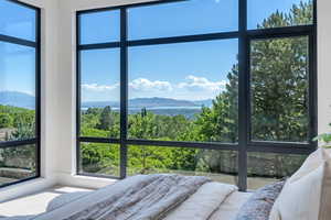 Bedroom featuring a mountain view and multiple windows