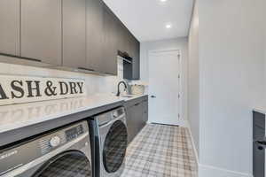 Washroom with cabinet space, separate washer and dryer, baseboards, and recessed lighting