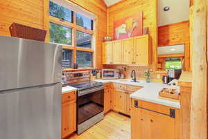 Full kitchen with solid surface countertops, stainless appliances and picture windows