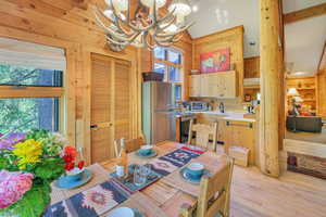 Dining space with 3 walls of windows, antler chandelier, wood floors and lofted ceiling