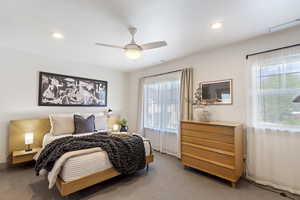 Carpeted bedroom featuring multiple windows, recessed lighting, ceiling fan, and baseboards