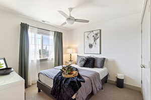 Bedroom featuring light carpet, baseboards, and ceiling fan