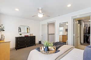 Bedroom with carpet floors, a walk in closet, baseboards, a closet, and ensuite bathroom