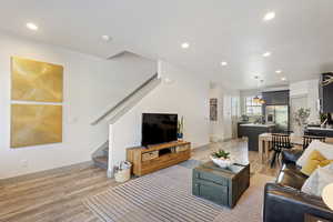 Living area featuring stairs, light wood-type flooring, recessed lighting, and baseboards