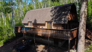 Back of property with a shingled roof and a deck