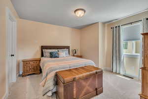 Bedroom with light colored carpet and baseboards