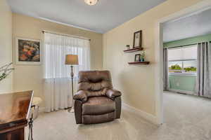 Sitting room featuring carpet flooring and baseboards