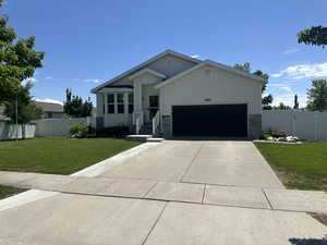 Single story home featuring an attached garage and concrete driveway