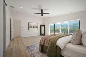 Bedroom with light wood finished floors, recessed lighting, baseboards, ceiling fan, and access to exterior