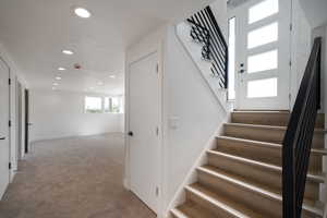 Stairs with recessed lighting, carpet, and baseboards