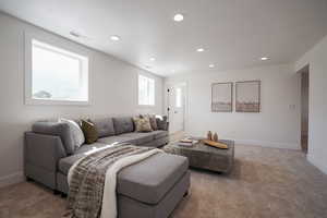 Living area with recessed lighting, carpet floors, and baseboards
