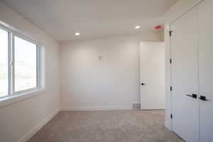 Carpeted spare room featuring recessed lighting and baseboards