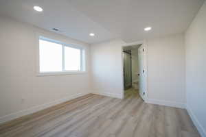 Unfurnished bedroom with light wood-style floors, recessed lighting, and baseboards