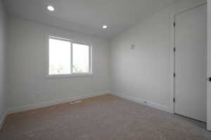 Carpeted empty room with baseboards and recessed lighting
