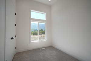 Carpeted empty room with baseboards and recessed lighting