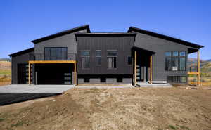 Contemporary house with a balcony, driveway, an attached garage, and a mountain view