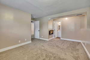 Unfurnished bedroom with carpet, baseboards, a textured ceiling, and connected bathroom