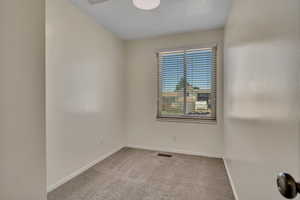 Carpeted empty room featuring baseboards