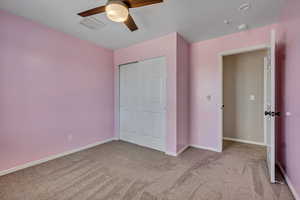 Unfurnished bedroom featuring carpet flooring, baseboards, and a ceiling fan