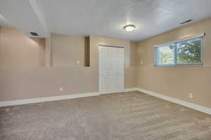 Unfurnished bedroom featuring baseboards, a closet, carpet floors, and a textured ceiling
