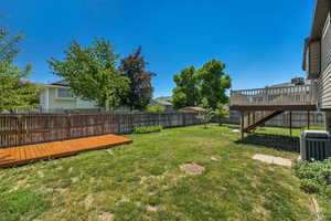View of yard featuring central AC unit, a wooden deck, and stairs