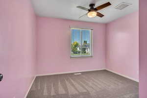 Empty room with a ceiling fan, carpet, baseboards, and a textured ceiling