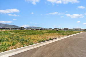 View of asphalt road with a residential view, curbs, and a mountain view