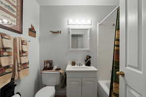 Bathroom with vanity, toilet, and shower / tub combo